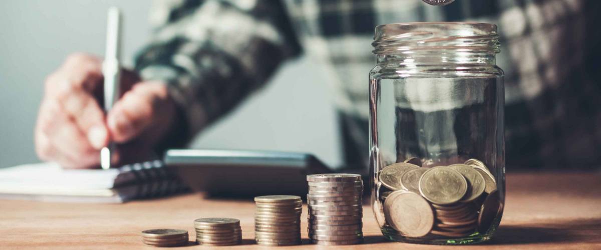 Business man putting coin in glass bottle saving bank and account for his money all in finance accounting concept.
