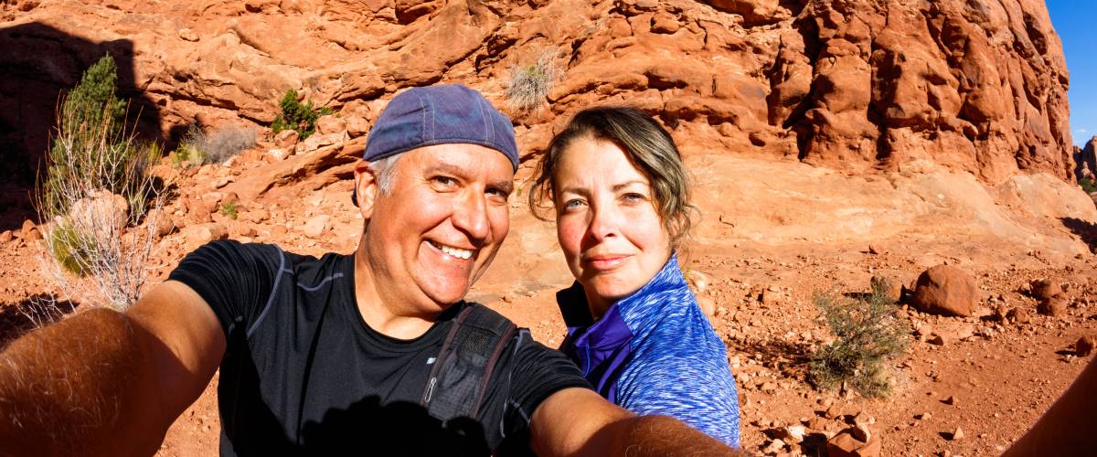 Older couple hiking near red rocks