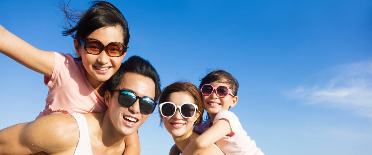 Family wearing sunglasses and having fun at the beach