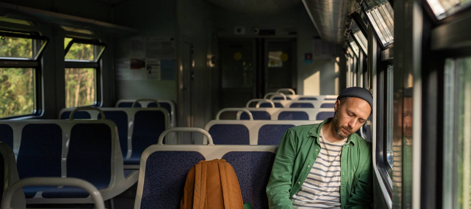 A man sleeps on a bus after an exhausting day.
