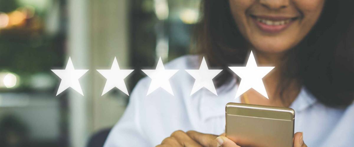 Businesswoman pressing five stars (5) rating on virtual touch screen at smartphone .Customer service evaluation concept.