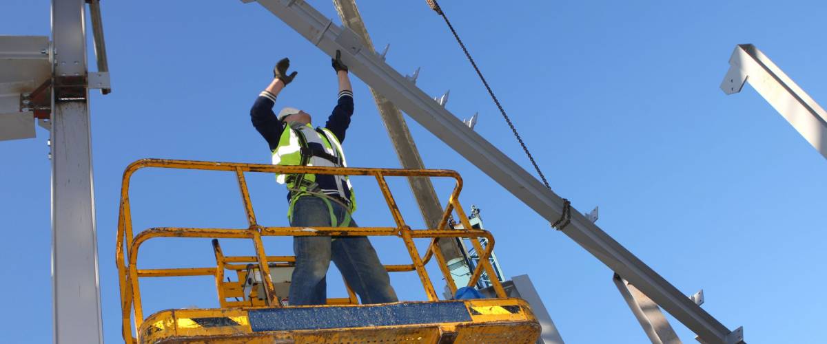 Steel worker on cherry picker.