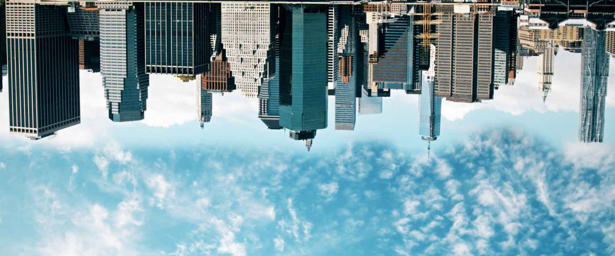 Abstract upside down cityscape on sky background. Wallpaper/backdrop with copy space