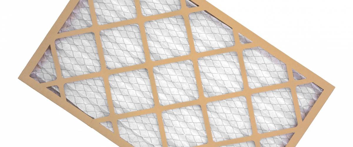 A new cardboard, wire mesh and fabric furnace filter on a white background.
