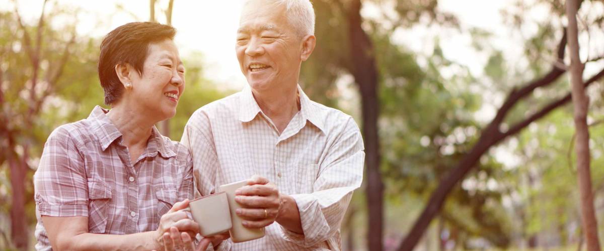 Healthy Asian senior couple drinking coffee in morning park together