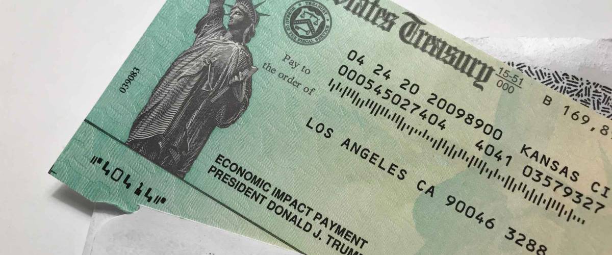 LOS ANGELES, April 28th, 2020: United States Treasury Economic Impact Payment stimulus check for Coronavirus COVID-19 relief. Close up with check sticking out of envelope.