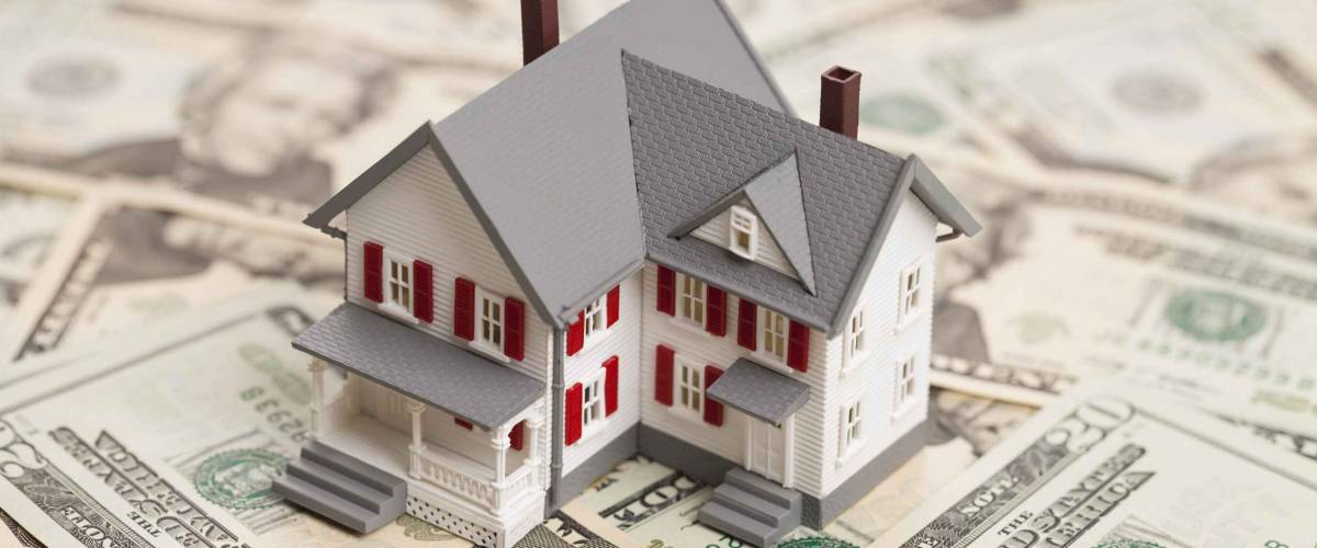 Single family house on pile of money. Concept of real estate.