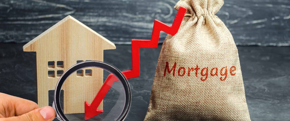 Bag with the money and the word Mortgage and arrow. Falling mortgage rates