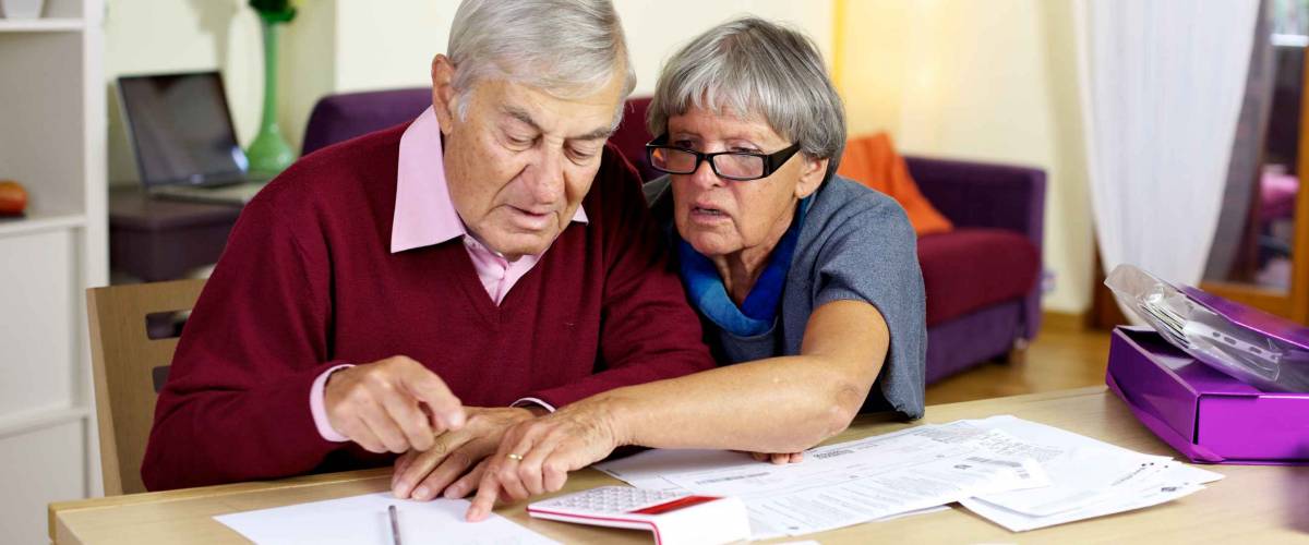 Senior couple at home calculating bills