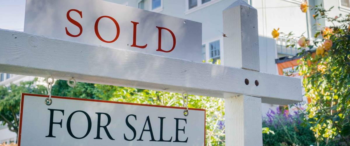 Sold sign in front of a house in a residential neighborhood, California