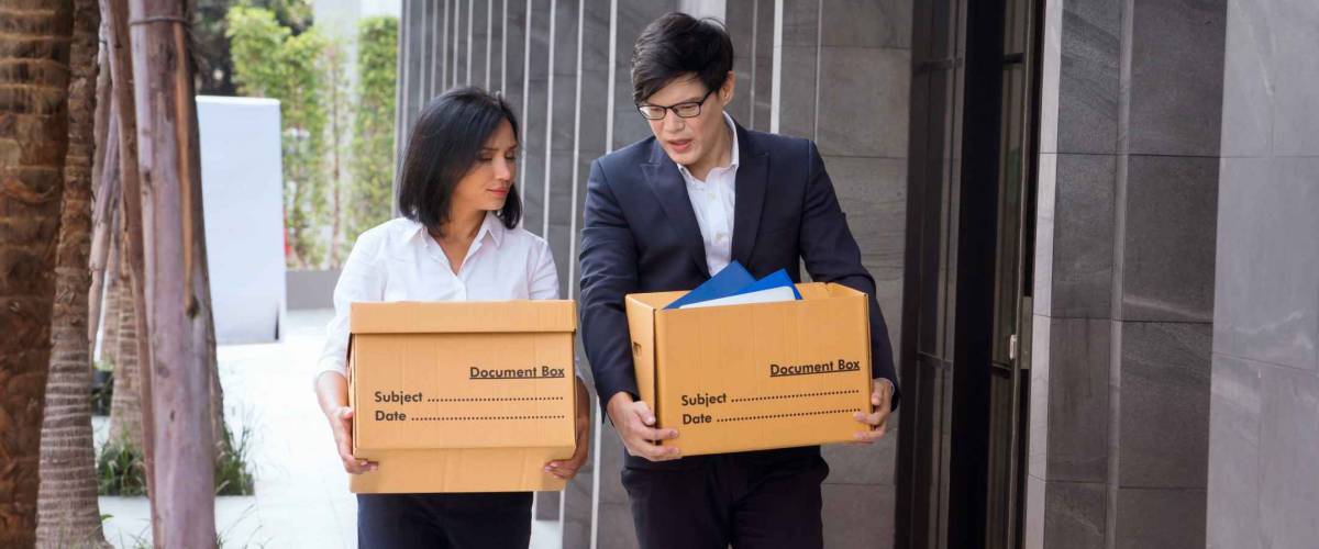 Male and female company employees are carrying their box out of the office because the company is closed or waste. Unemployed man, The economic downturn made people unemployed.