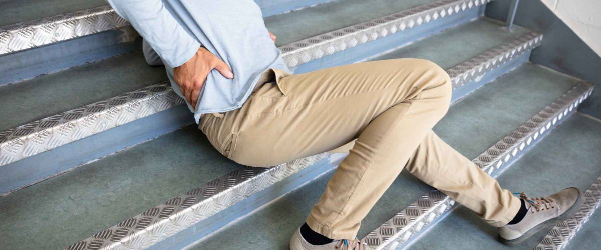 Mature Man Lying On Staircase After Slip And Fall Accident
