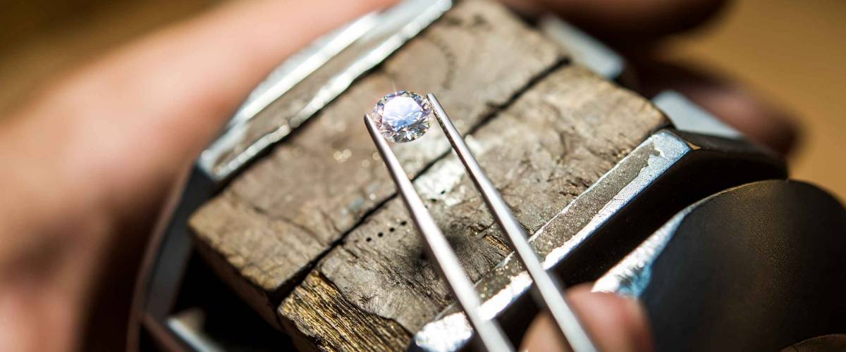 Craft jewelery making with professional tools. Ring repairing. Putting the diamond on the ring. Macro shot. A handmade jeweler process, manufacture of jewelery.