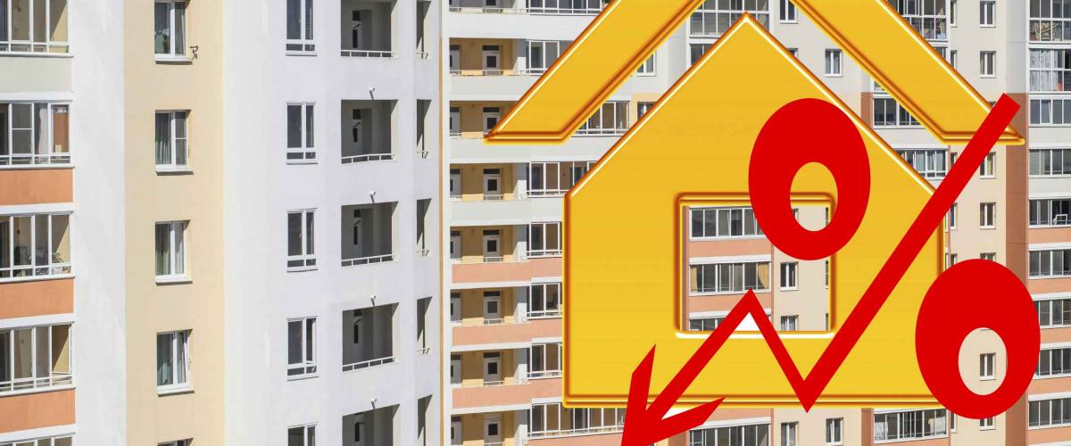 Red percent sign on the background of houses . The concept of price changes on the real estate market .