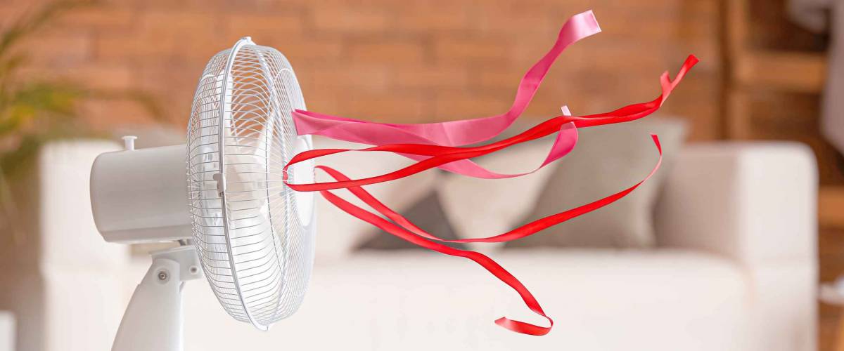 Electric fan with fluttering ribbons in room