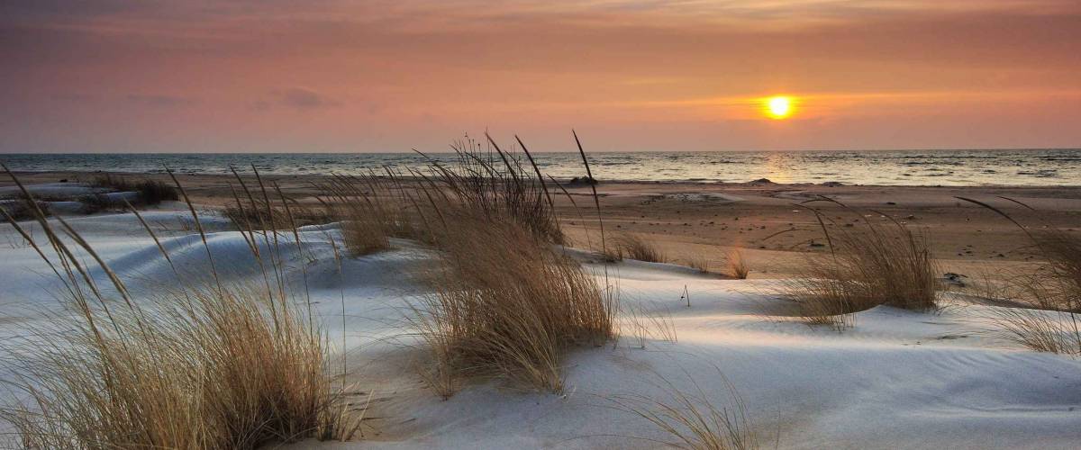 Beautiful Lake Huron Sunrise, Tawas Point State Park, Michigan USA Snow and ice mix with the drifting sand making this a pretty winter scene.