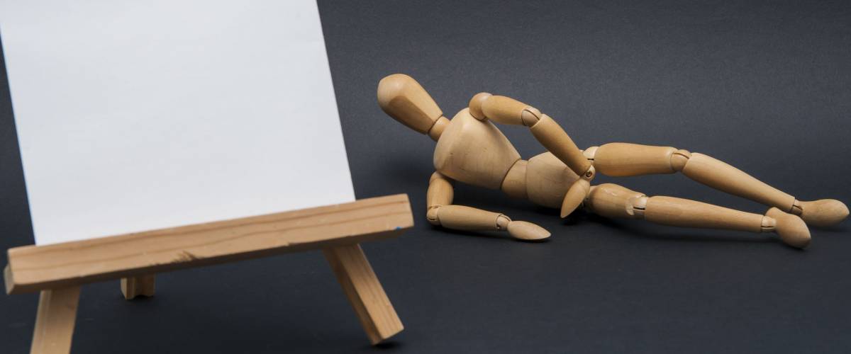 Painting a model/Painting easel with a fresh new white canvas on prepared for painting and a model in the out of focus background represented by a wooden dummy.