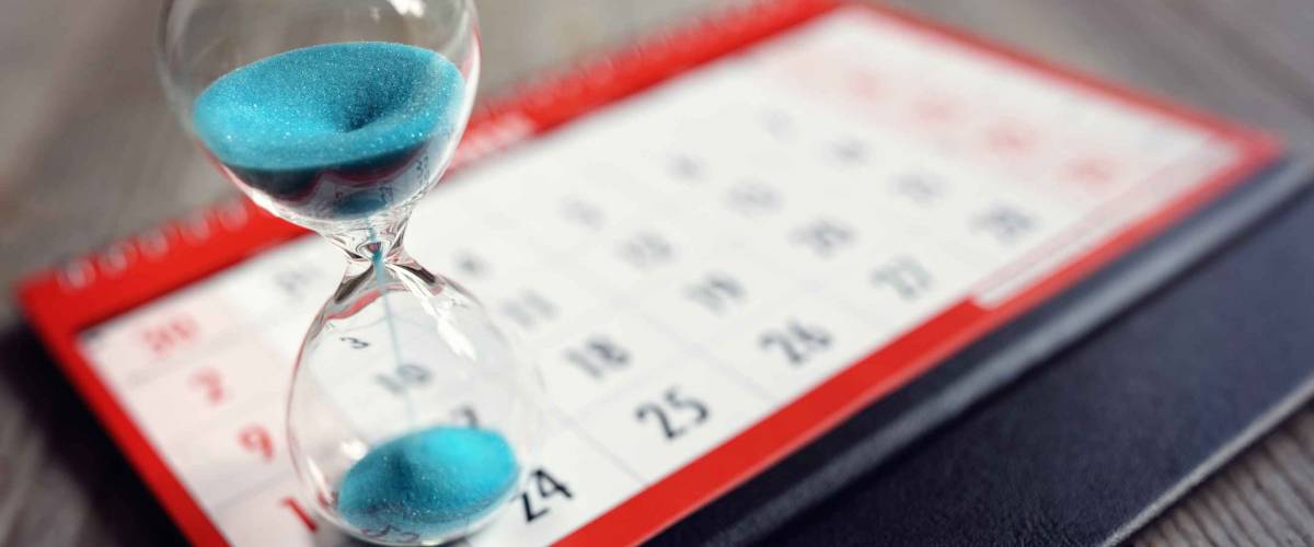 Hour glass on calendar concept for time slipping away for important appointment date, schedule and deadline
