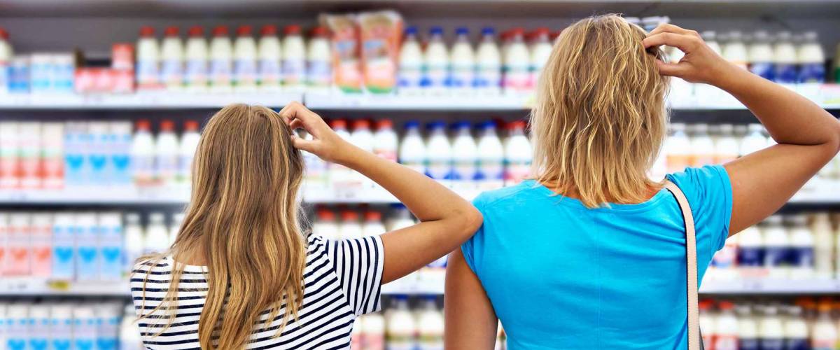 Mother and children are choosing dairy products in shop