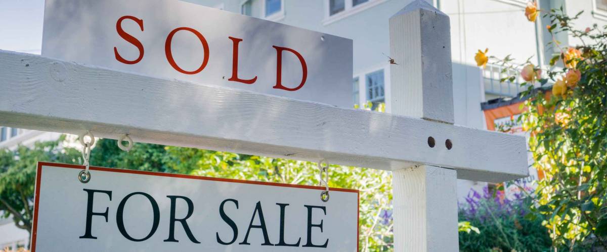Sold sign in front of a house in a residential neighborhood, California