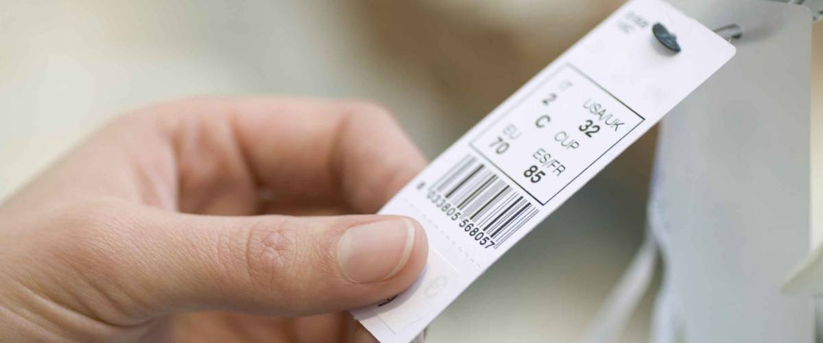 Closeup of woman's hands holding clothes tag in store