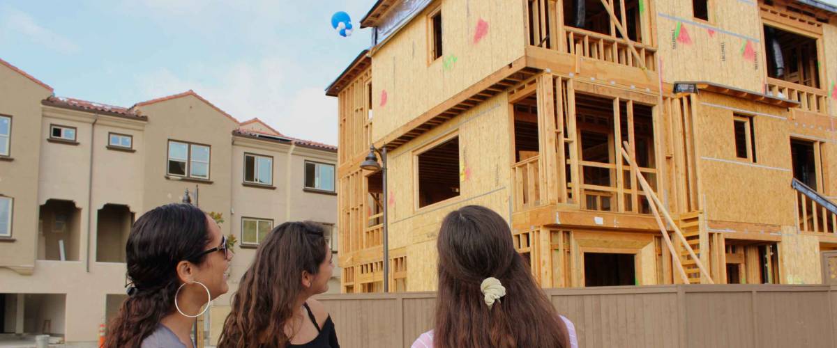 Vista, CA / USA - October 6, 2018: A mother and her teen daughters looking at newly built townhomes for sale