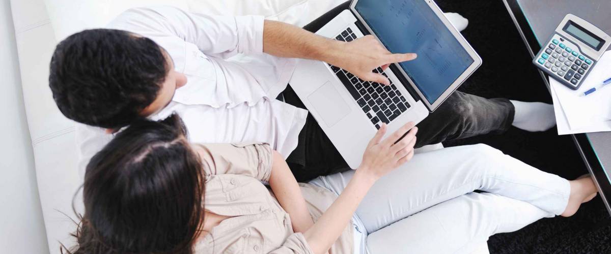 joyful couple relax and work on laptop computer at modern living room indoor home