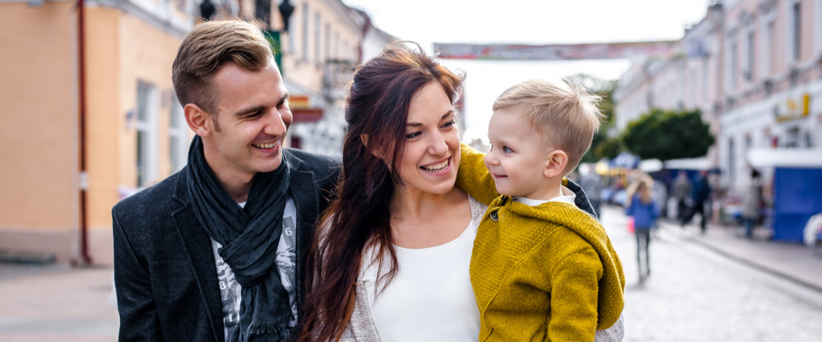 Parents walking with their son through an urban city centre