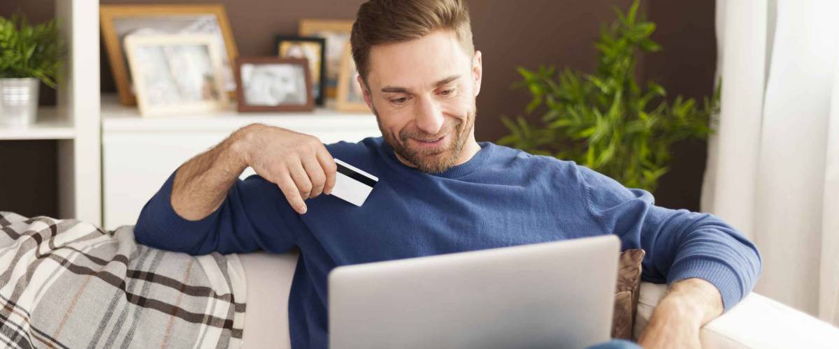 Smiling man during online shopping at home