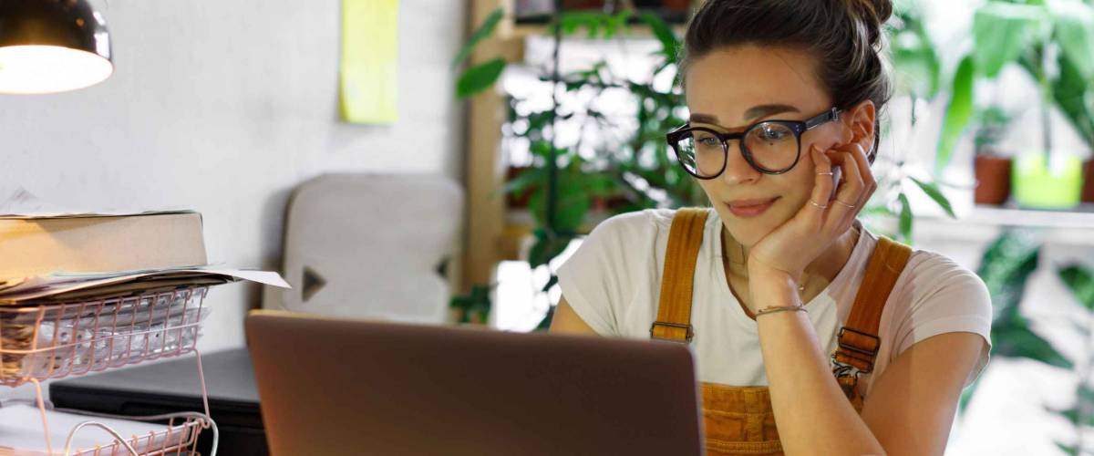 Young woman in glasses using laptop