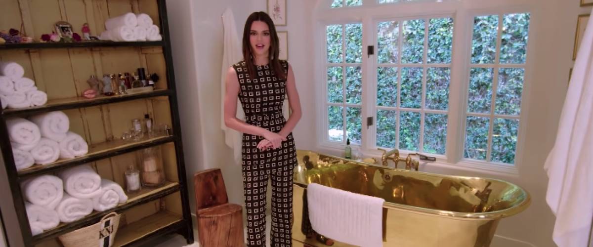 Kendall Jenner stands in front of a gleaming bronze bathtub.