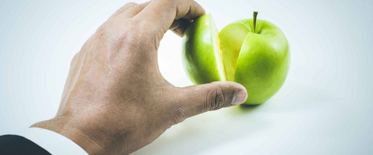 Business market share and success concept.Businessman hand pick a piece of green apple up .
