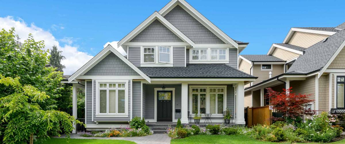 Luxury house with beautiful landscaping on a sunny day. Home exterior.
