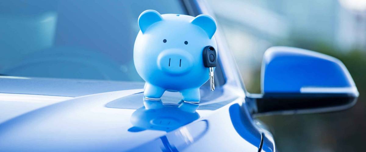 Closeup image new car with piggy bank, illustrating car insurance