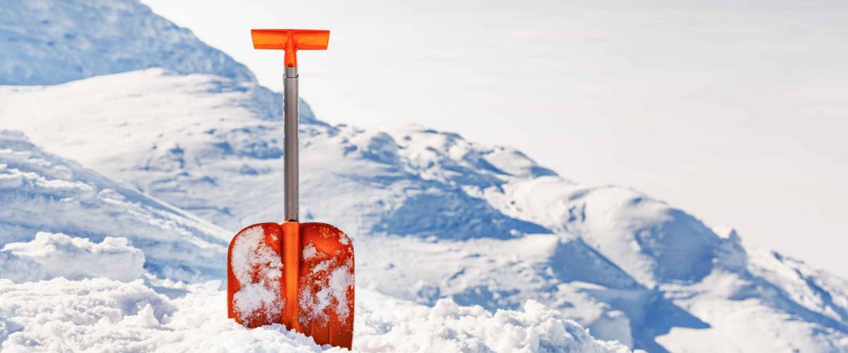 Shovel for snow cleaning during snowfall or avalanche. Snow storm in winter time season. Tool for maintenance during drive away.