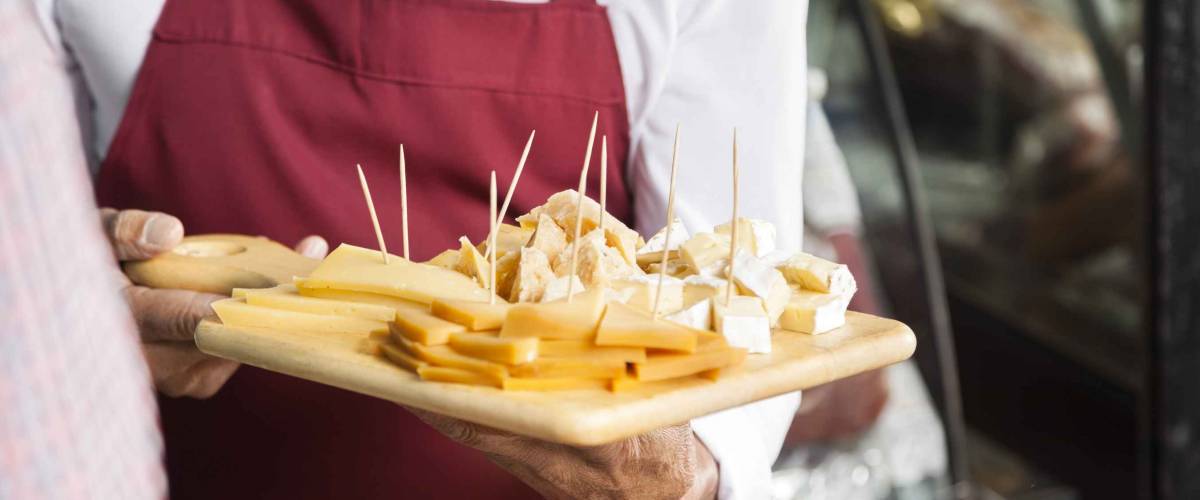 Salesman Holding Cutting Board With Assorted Cheese