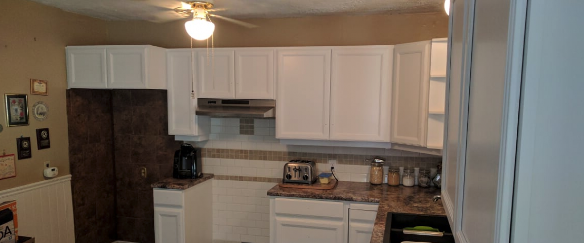 Poorly decorated dark kitchen with missing stove.