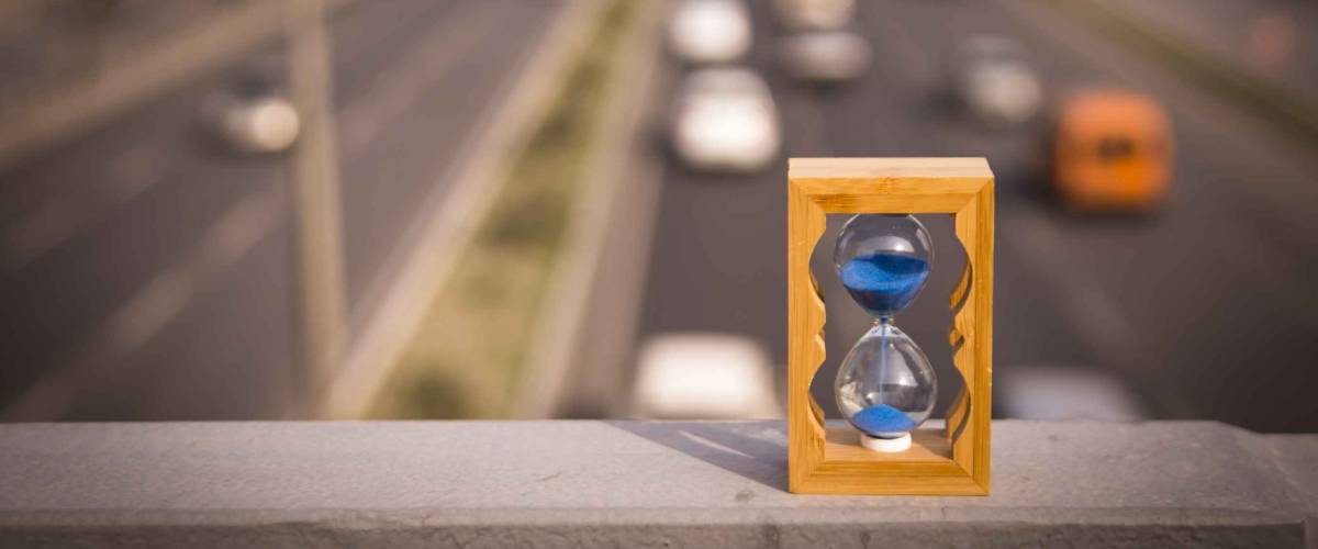 Hourglass on bridge. We can see the road and traffic.