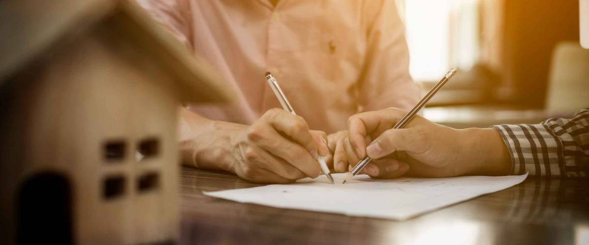 Real-estate agent sign for home contract property for sale in the office with buyer.