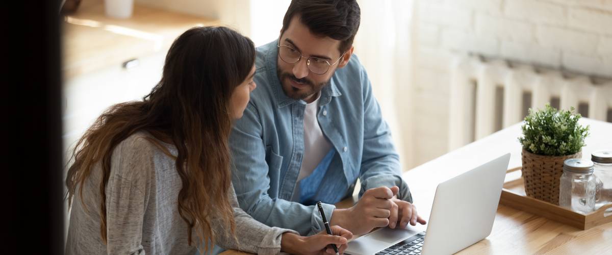Couple at desk with laptop discussing money