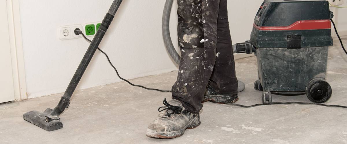 Worker man use vacuum cleaner in construction
