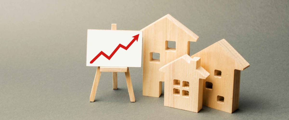 three wooden houses and a red up arrow on the sign. Real estate value increase. High rates of construction, high liquidity. Supply and demand. Rising prices for housing, building maintenance.