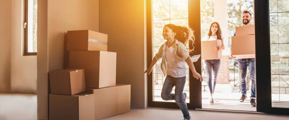 Happy family with cardboard boxes in new house at moving day.