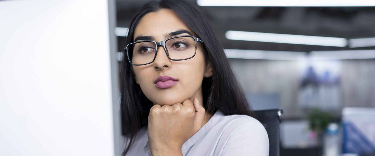 Serious young businesswoman working at computer