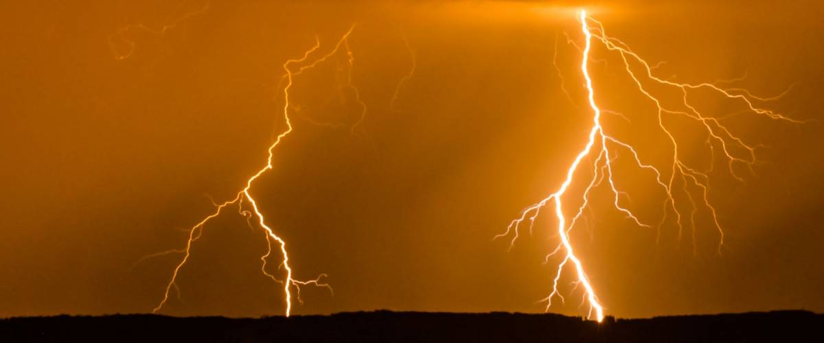 Double lightning in the night with red sky during stormy weather
