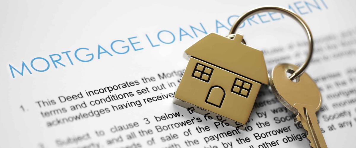 Mortgage loan agreement application with house shaped keyring on top