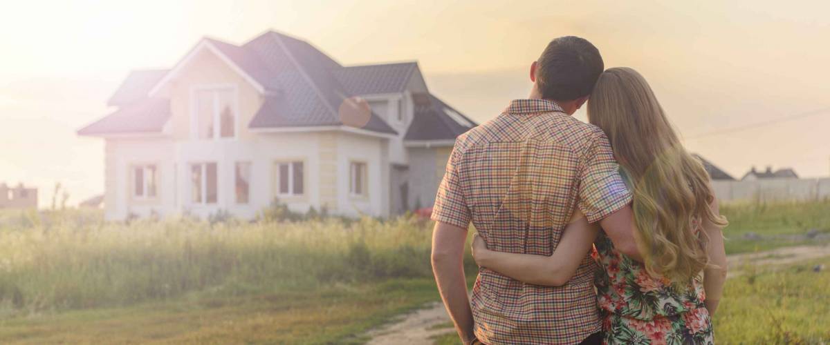 rear view of young couple looking at their new house