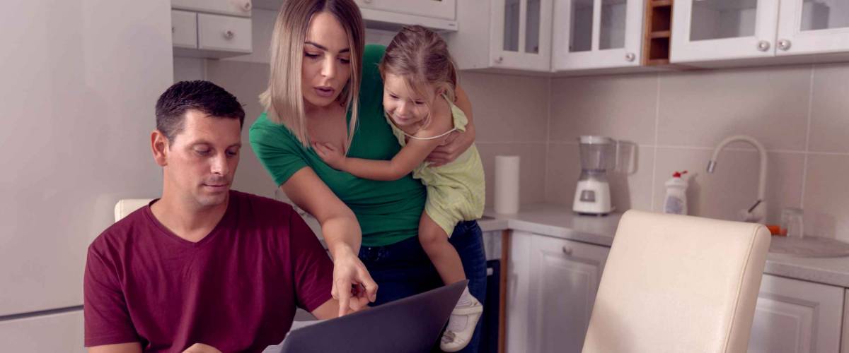 Worried young parent calculating bills at home