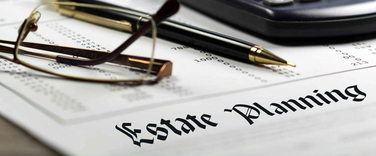 Estate planning. Calculator, glasses and black pen on financial documents