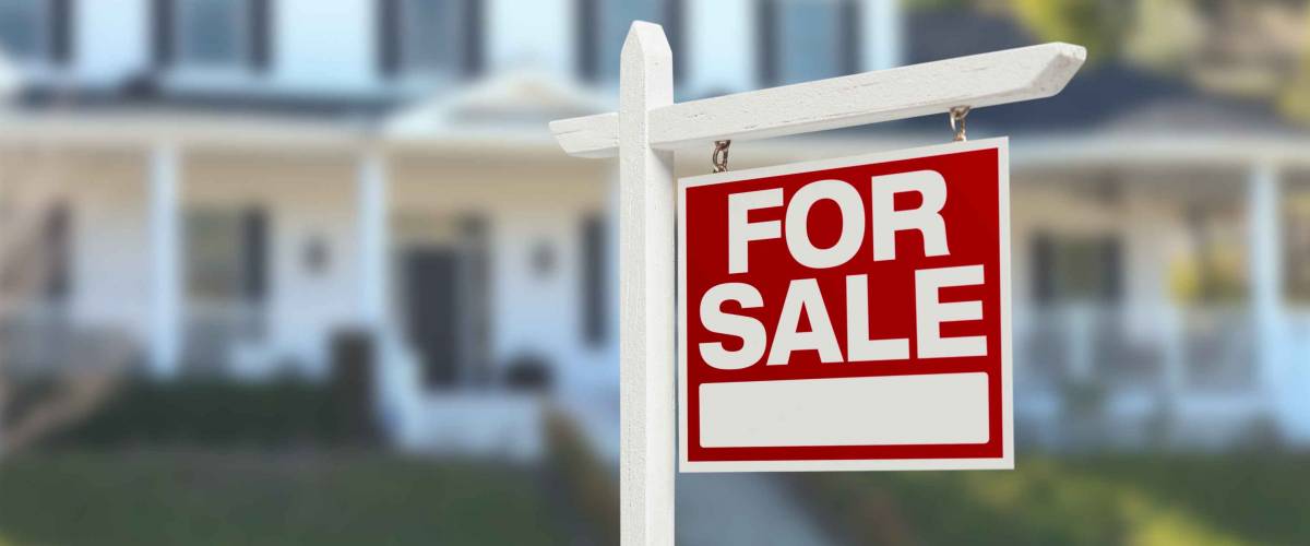 Home For Sale Real Estate Sign in Front of Beautiful New House.
